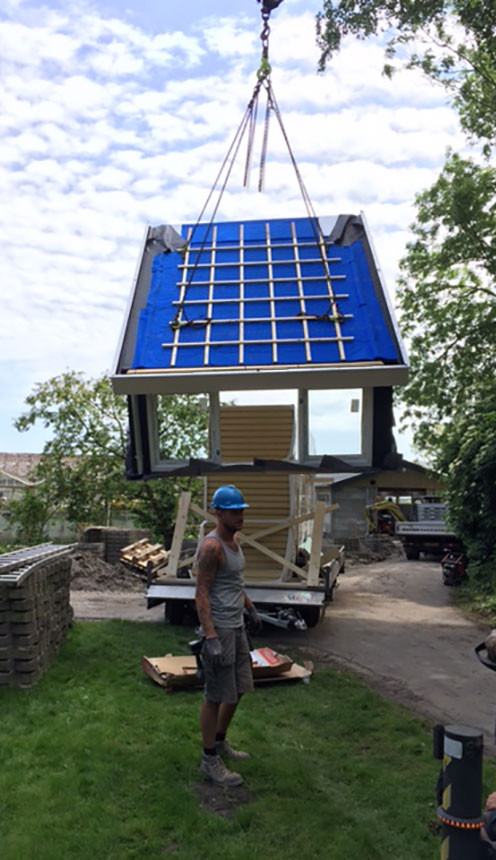 Wognum prefab dakkapel aan de hijskraan net boven de grond.