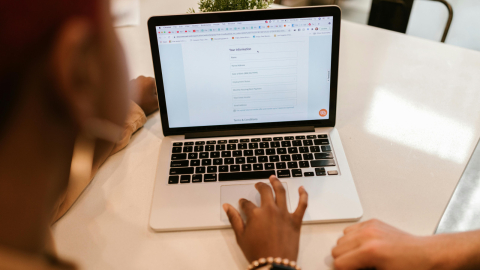 vrouw achter laptop om subsidie aanvraag te doen